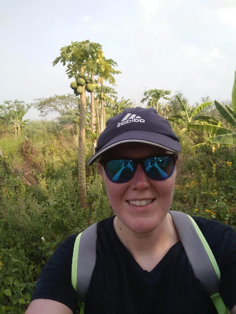 Kayla Dhankhar in sunglasses and a hat hiking in Myanmar