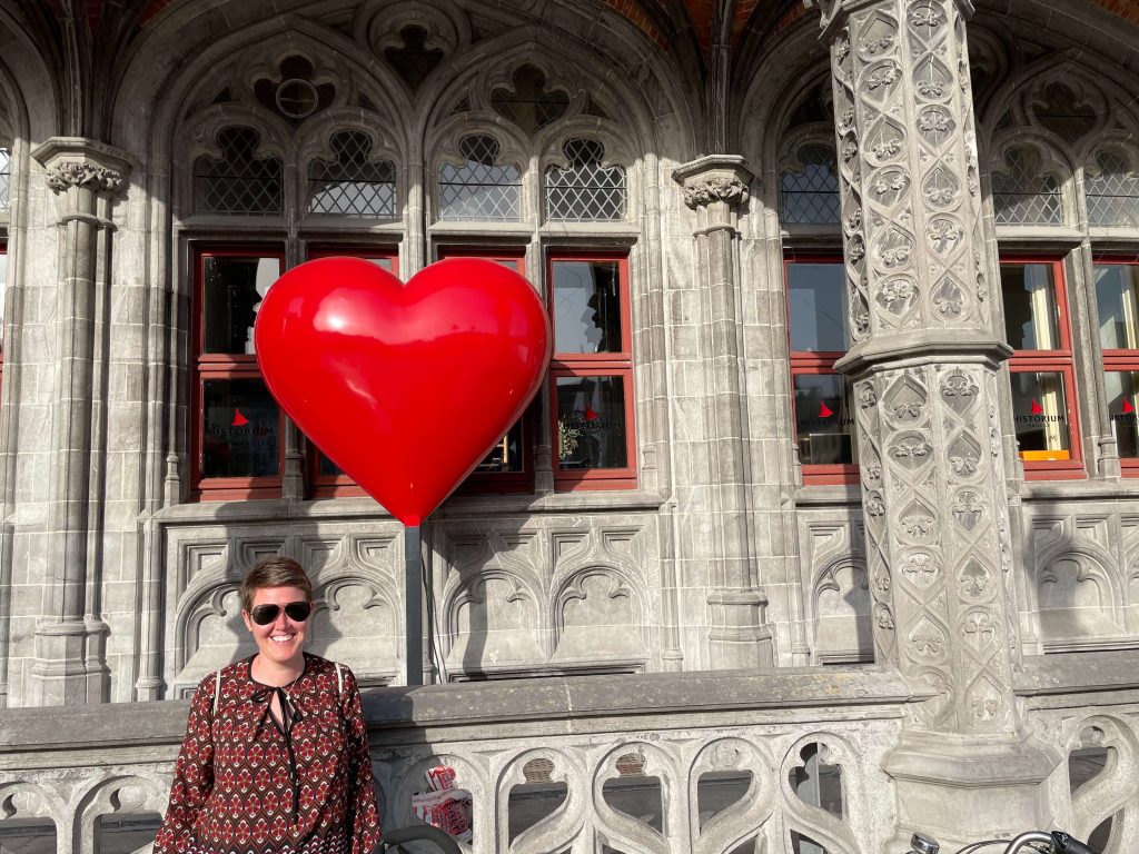 Kayla Dhankhar standing in front of a giant red heart in Brussels