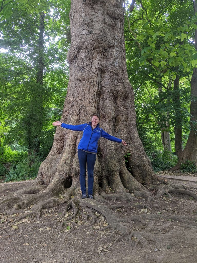 Kayla Dhankhar with a huge tree to connect to the healing energy of nature