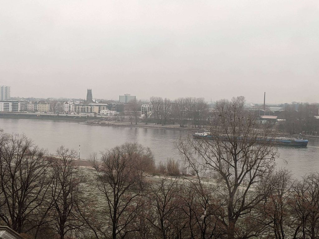 Rhine river in Germany cloudy and dark with light snow on the ground